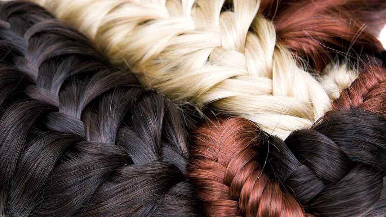 A pile of braided hair extensions in black, blonde and red colors
