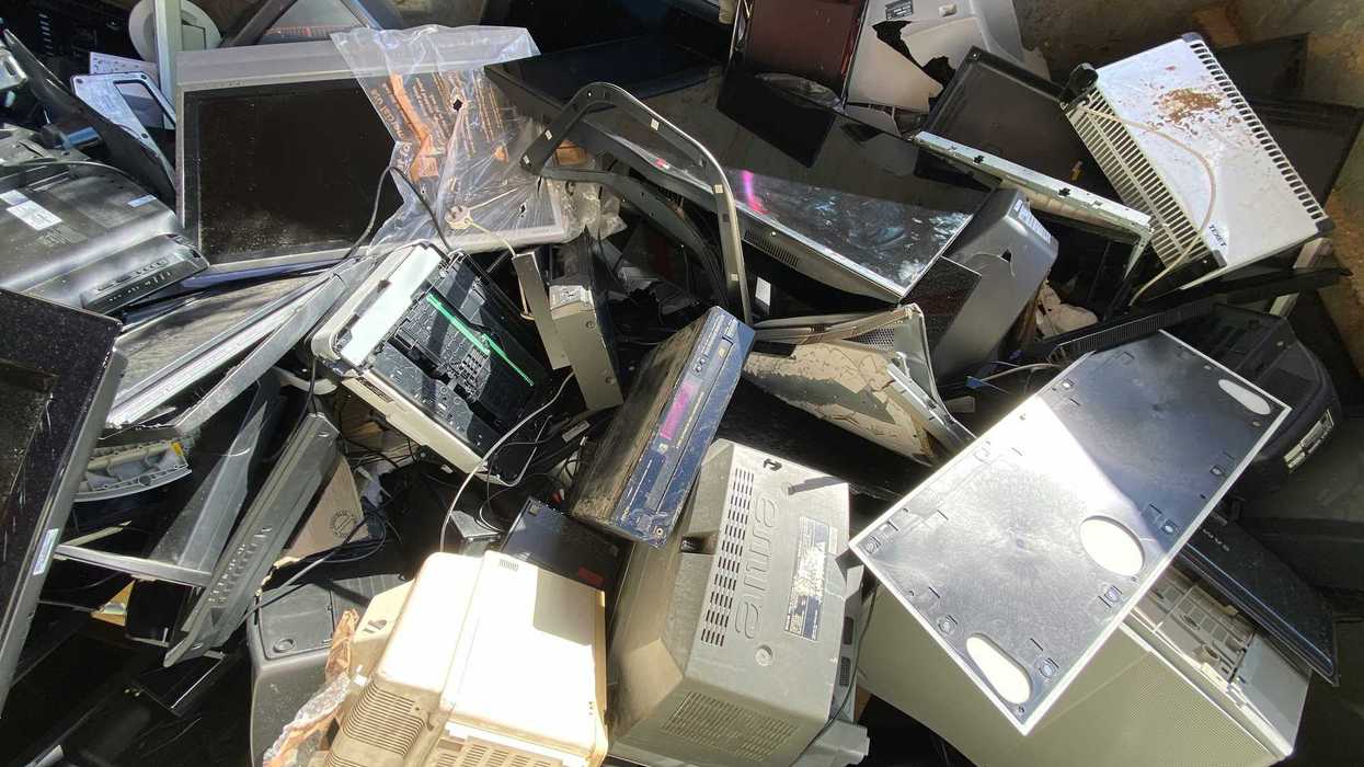 A pile of old computer towers and monitorrs