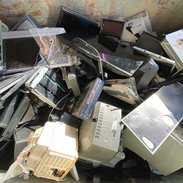 A pile of old computer towers and monitorrs
