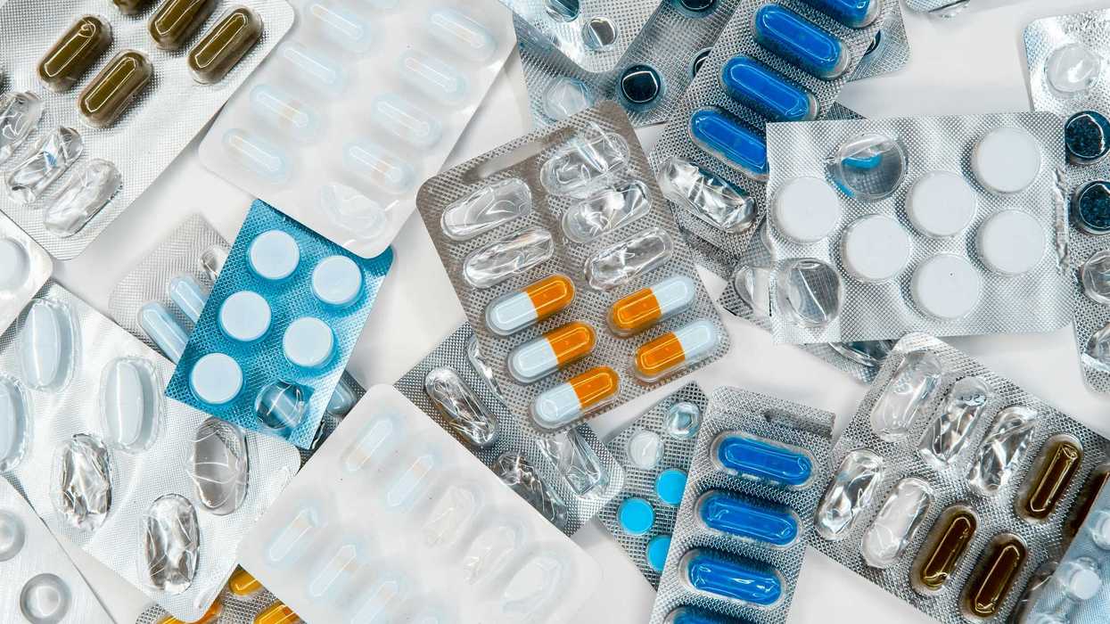 a pile of pills in blister packs sitting next to each other on top of a table.