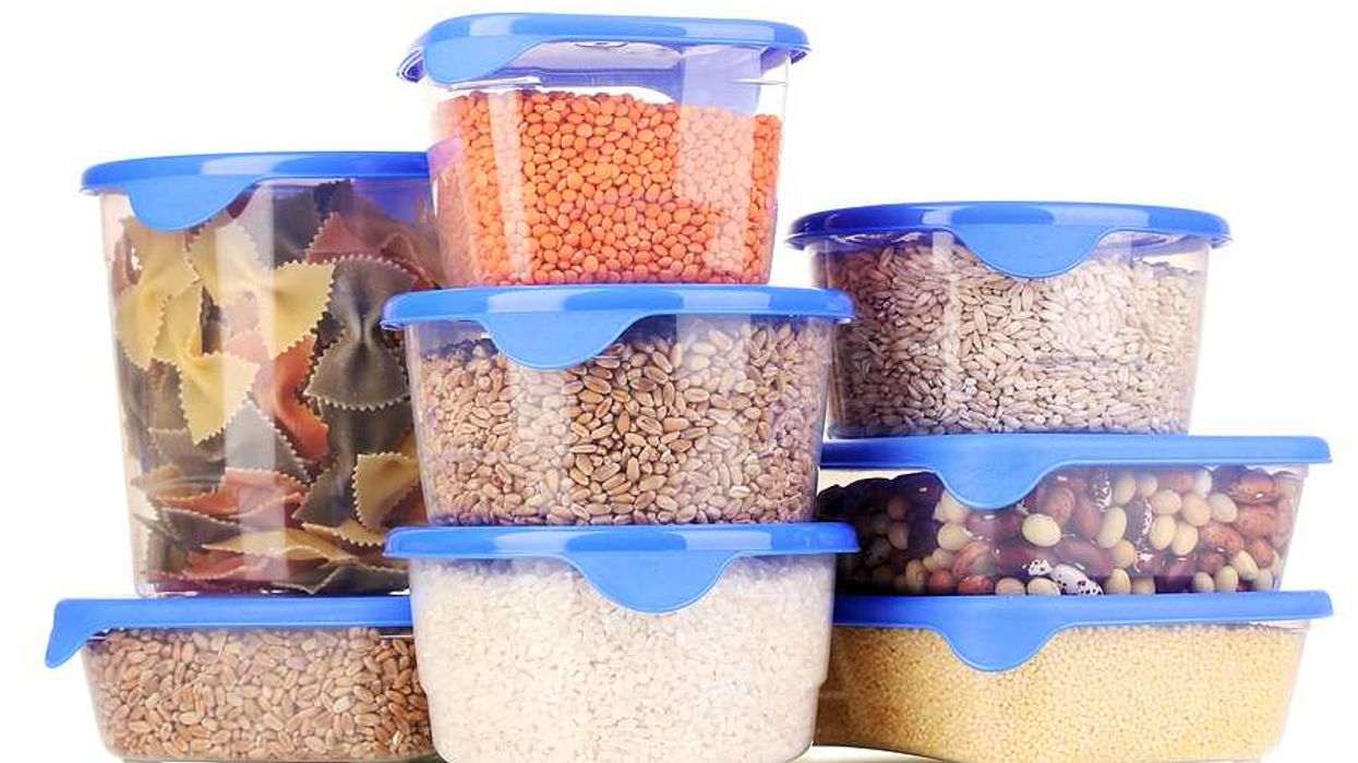 A pile of plastic food containers with pasta and beans and rice