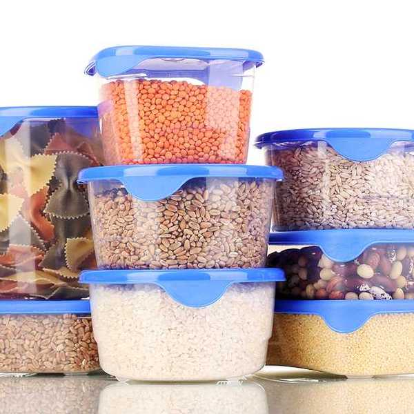 A pile of plastic food containers with pasta and beans and rice