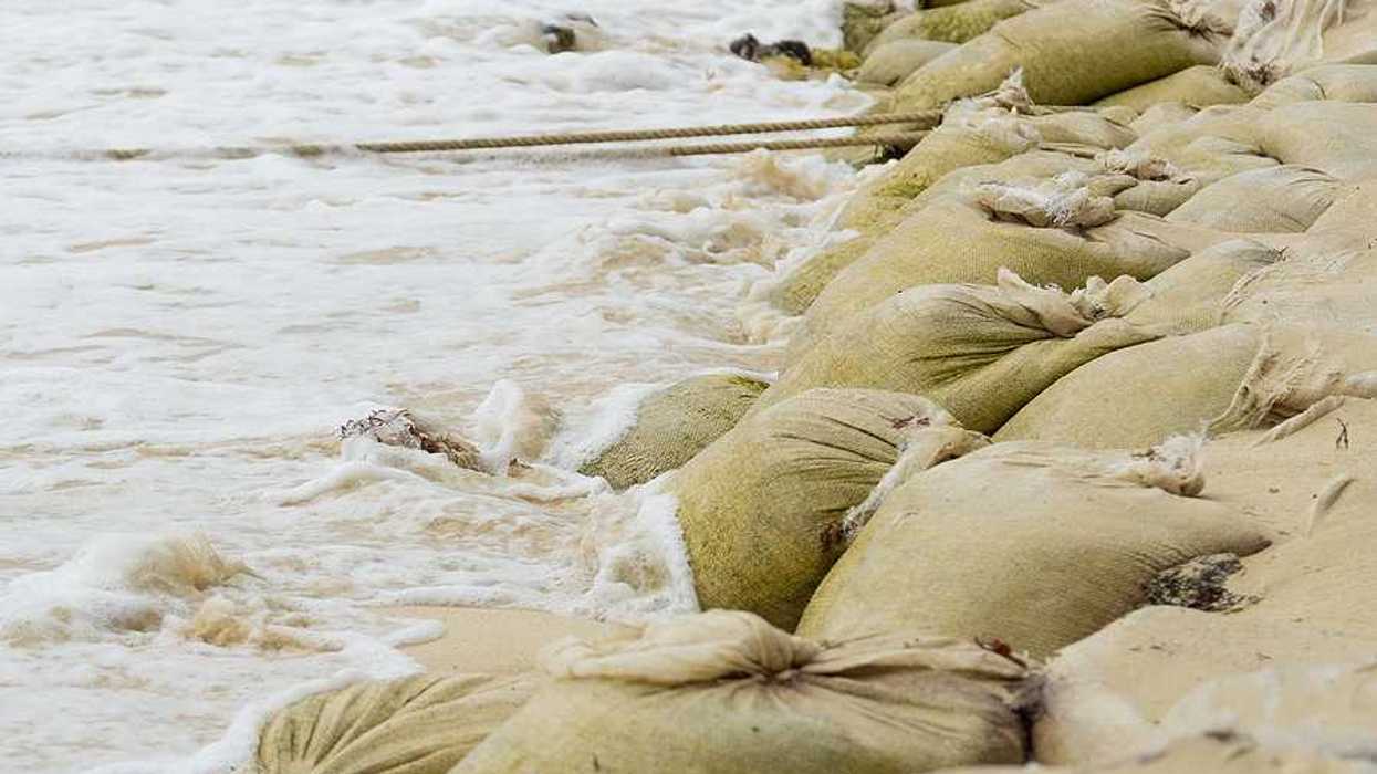 A pile of sandbags helping to keep waves from flooding the beach