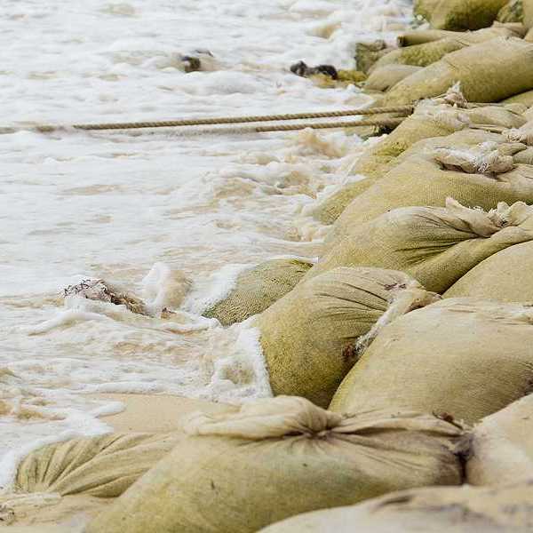A pile of sandbags helping to keep waves from flooding the beach