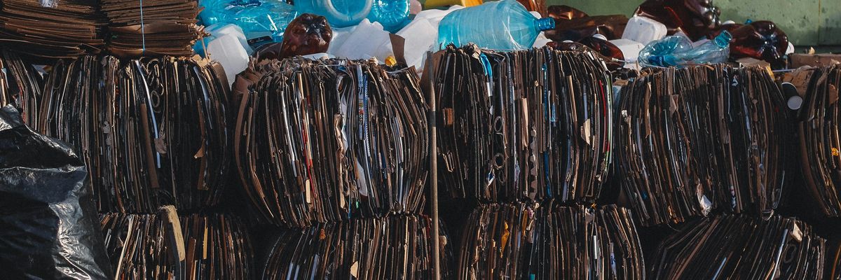 a pile of trash bundles sitting next to a green wall.