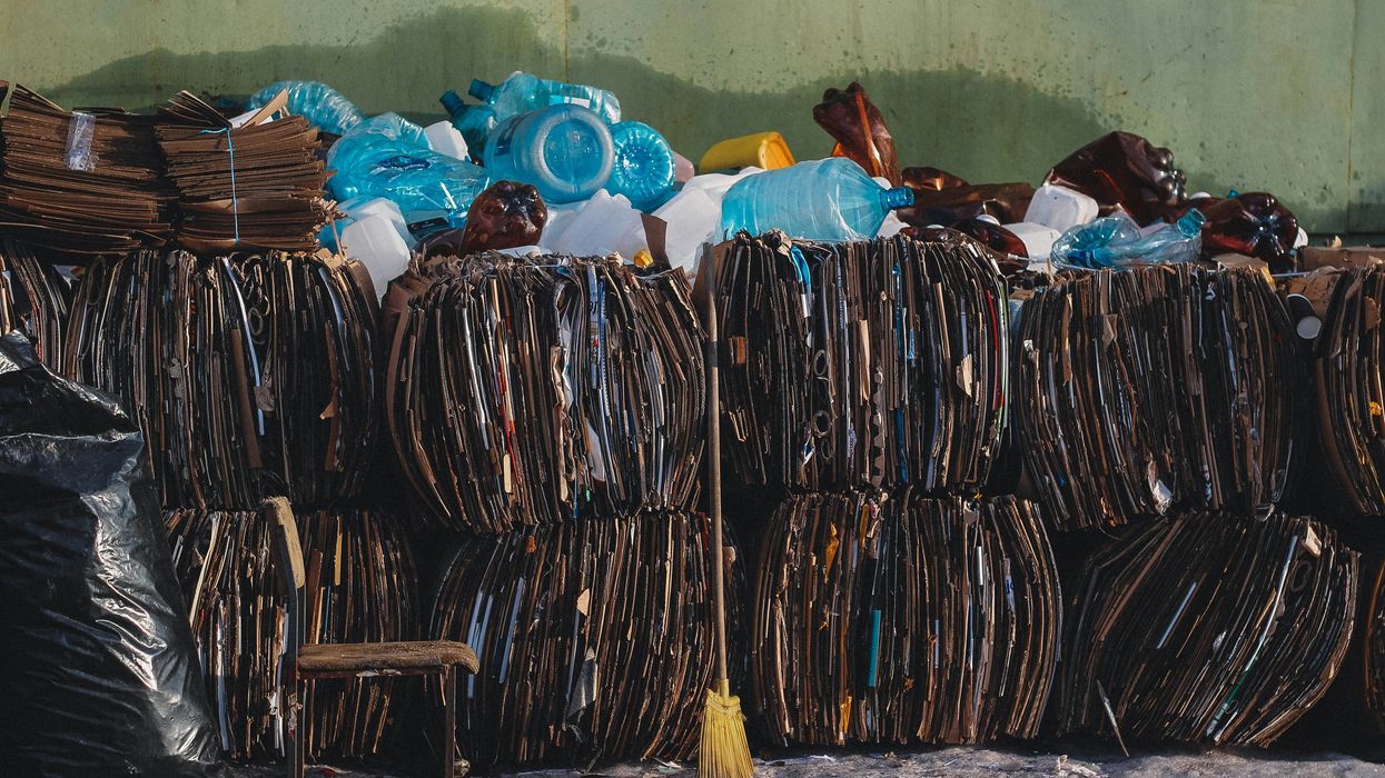 a pile of trash bundles sitting next to a green wall.