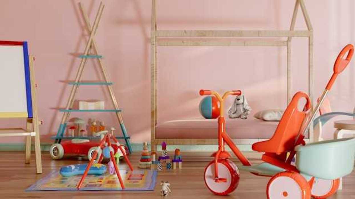 A pink room with childrens' toys littered on the flood