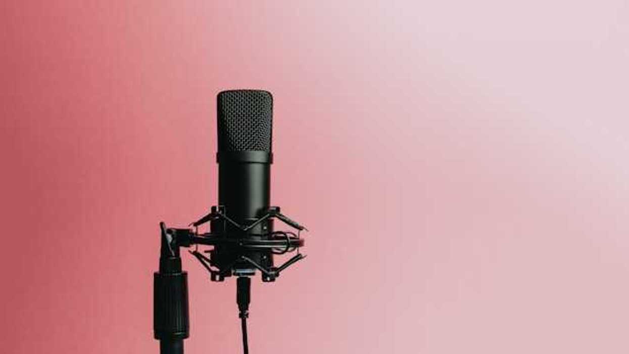 A podcast microphone against a pink background