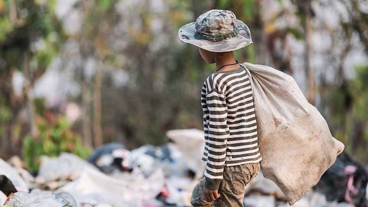 A poor boy collecting garbage waste from a landfill site.