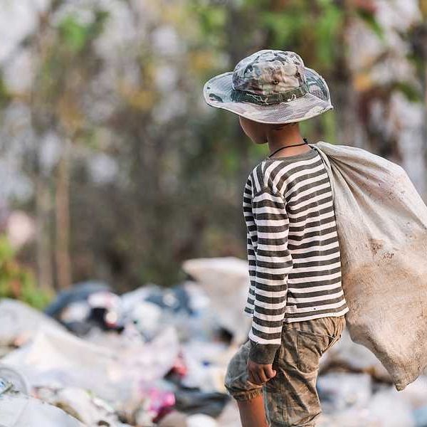 A poor boy collecting garbage waste from a landfill site.