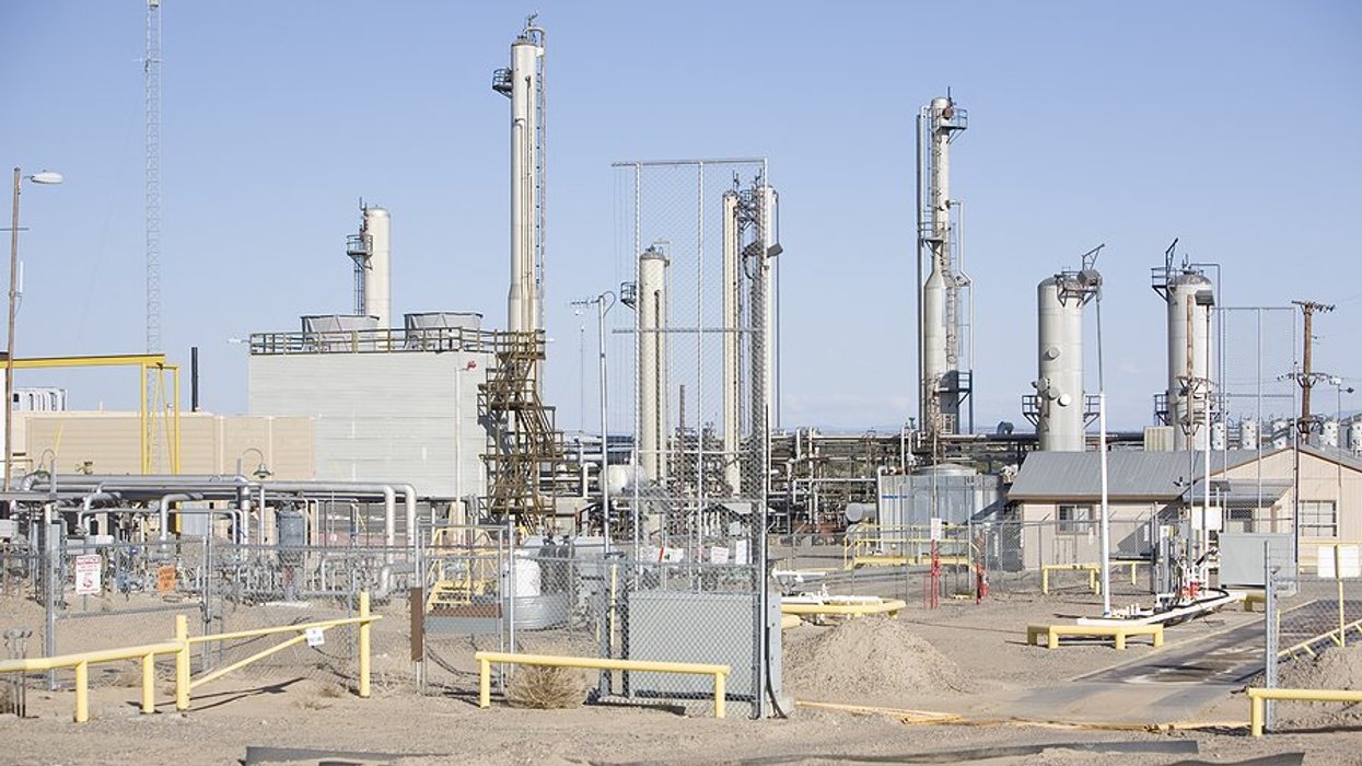 A power plant with silver towers, pipes and industrial equipment