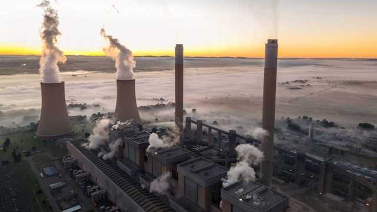 A power plant with smoke arising from smokestacks