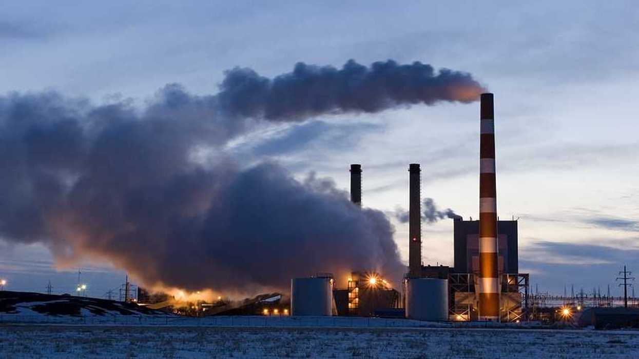 A power plant with smoke emitting from the smokestacks