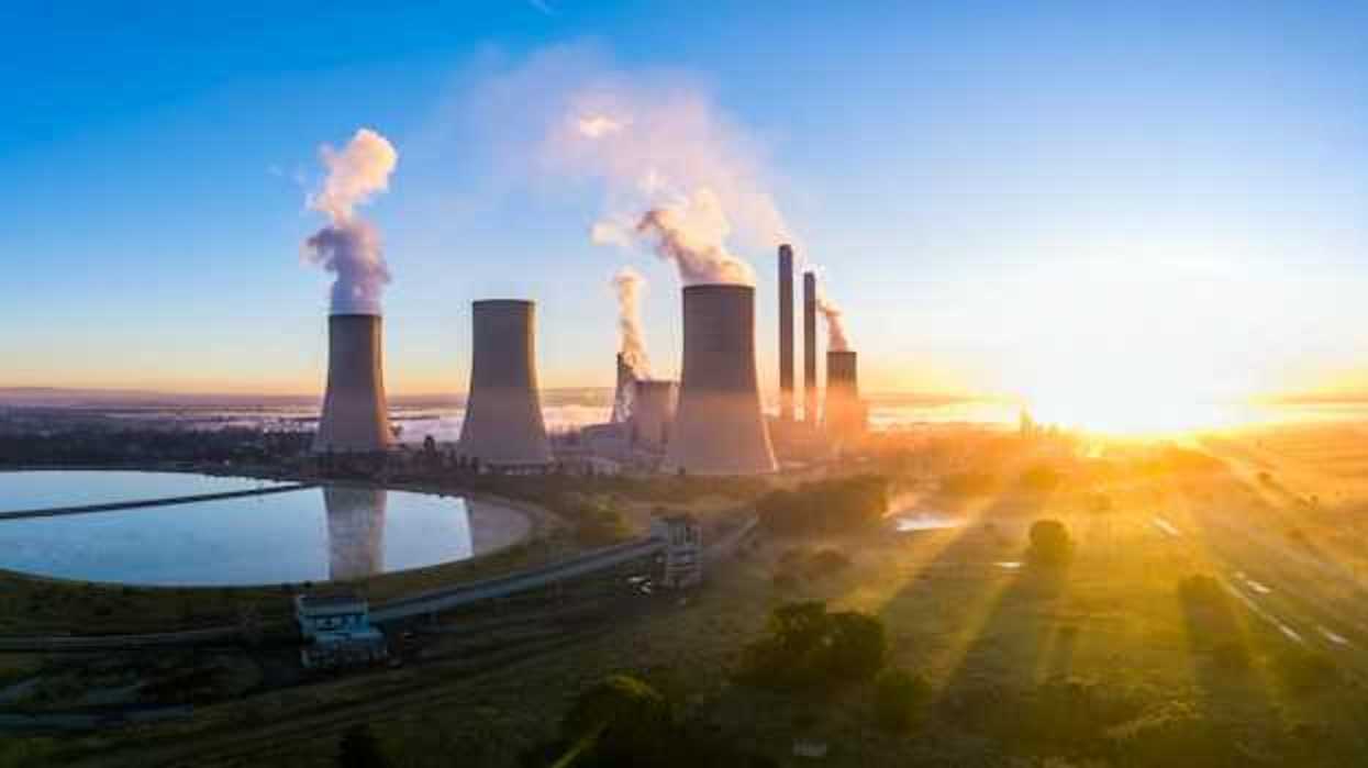 A power station with cooling towers seen at sunrise