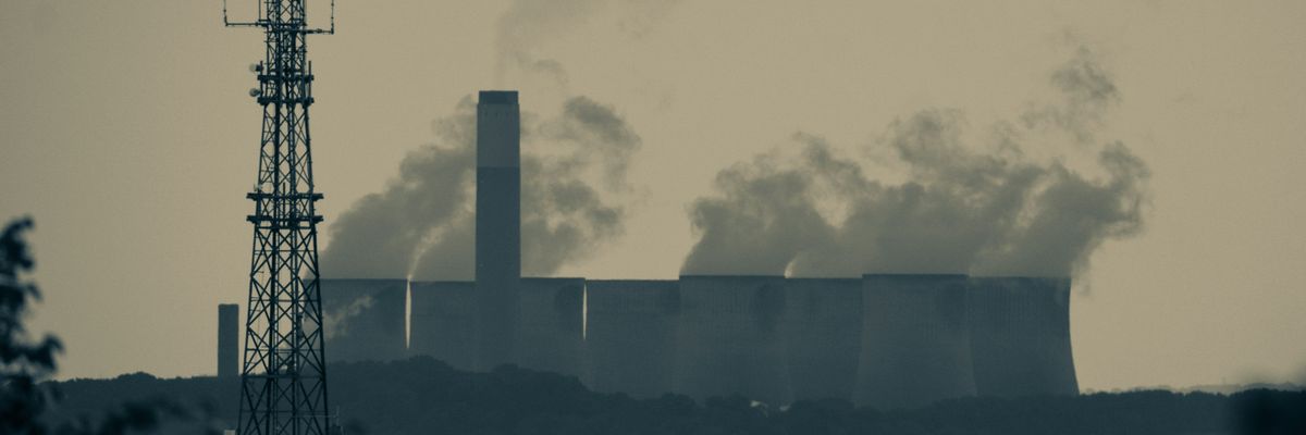 A power station with smoke billowing from towers