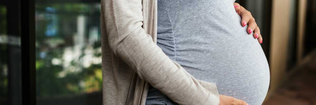 A pregnant woman holds her stomach