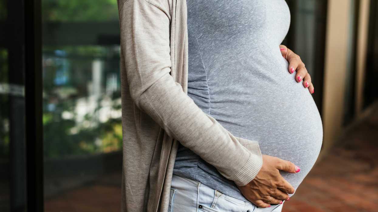 A pregnant woman holds her stomach