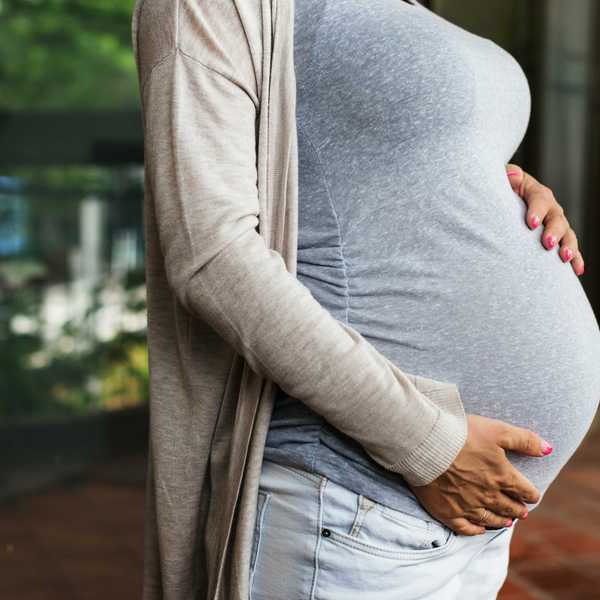 A pregnant woman holds her stomach