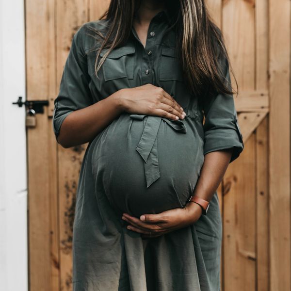 A pregnant woman in a green dress