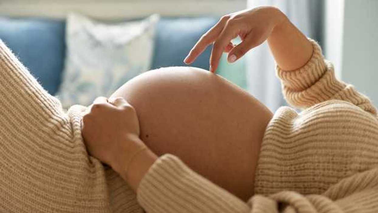A pregnant woman lying on her back in her living room