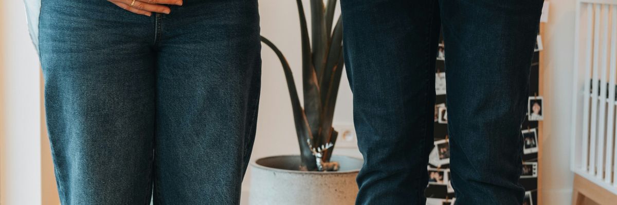 a pregnant woman standing next to a man