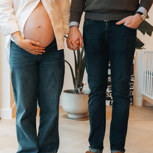 a pregnant woman standing next to a man
