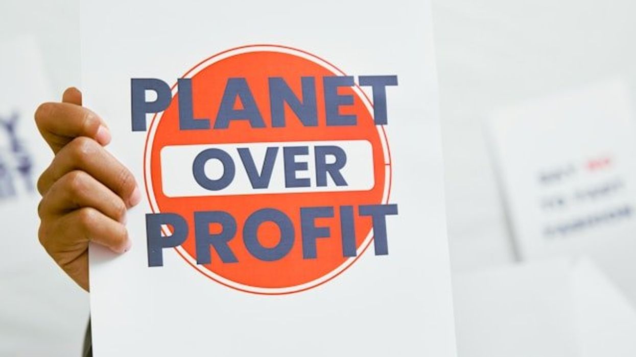 A protest sign that says Planet Over Profit.