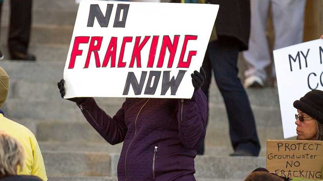 A protester with a sign that states "No Fracking Now"