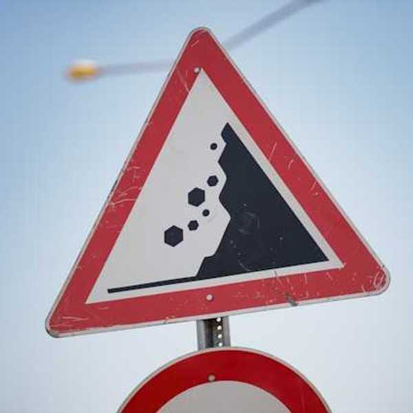 A red and black road sign warning of landslide danger