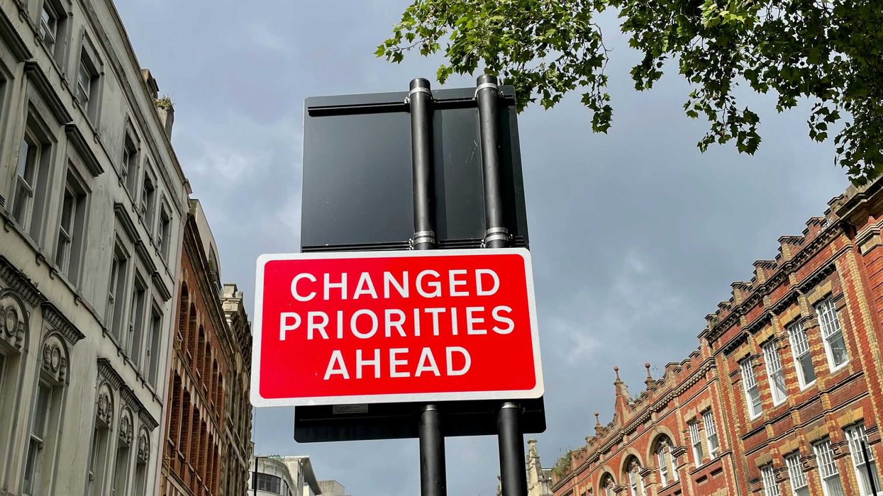 A red and white street sign saying Changed Priorities Ahead