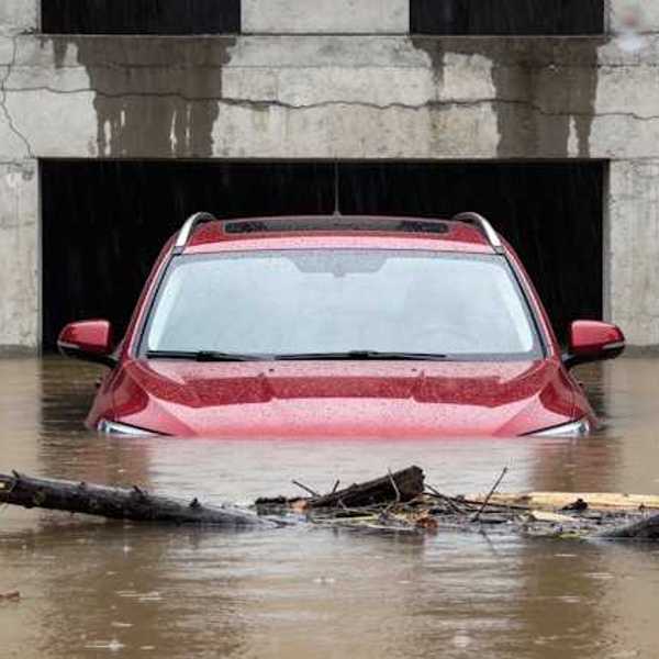 A red car submerged under flood waters
