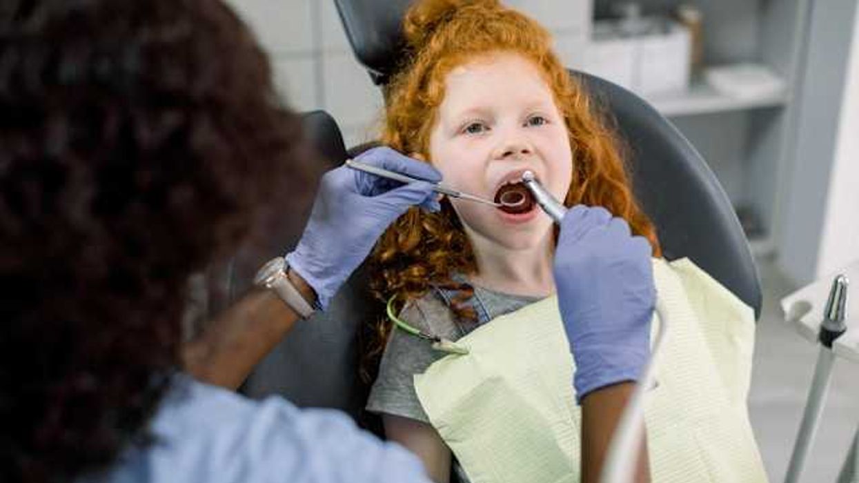 A red haired girl in a dentist's chair having her teeth examined