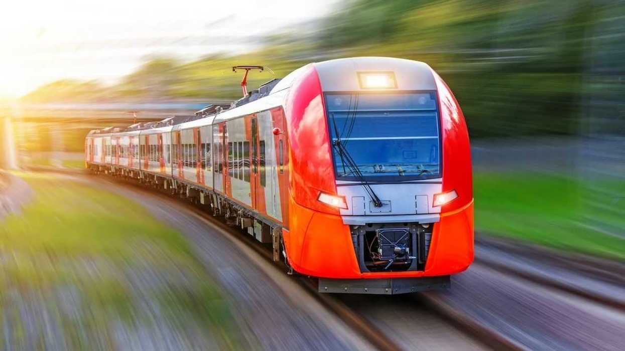 A red, high-speed passenger train hurtling down the tracks