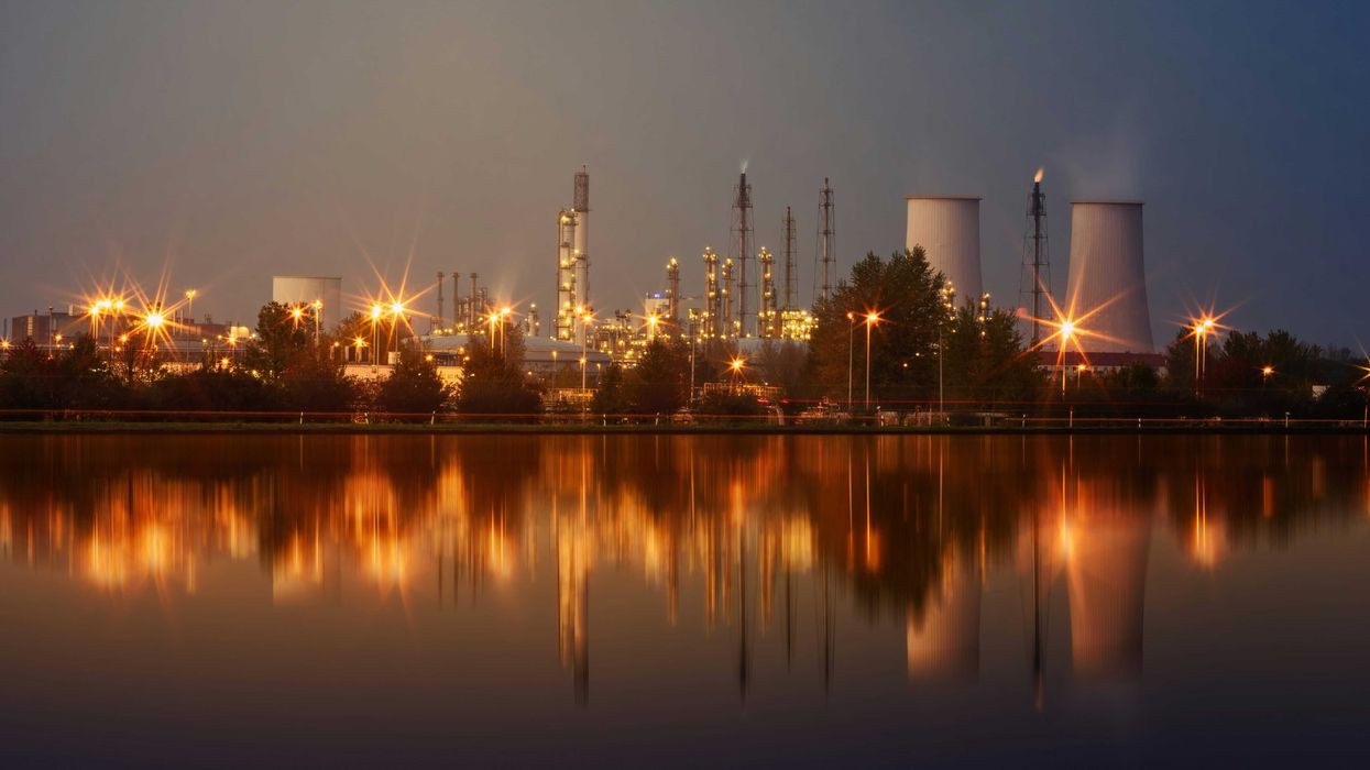 A refinery at night in front of a water source
