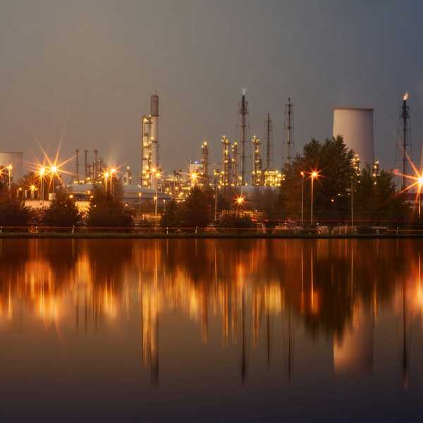 A refinery at night in front of a water source