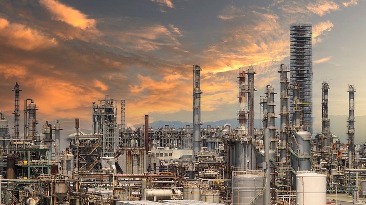 A refinery under a pink, cloud-strewn sky.