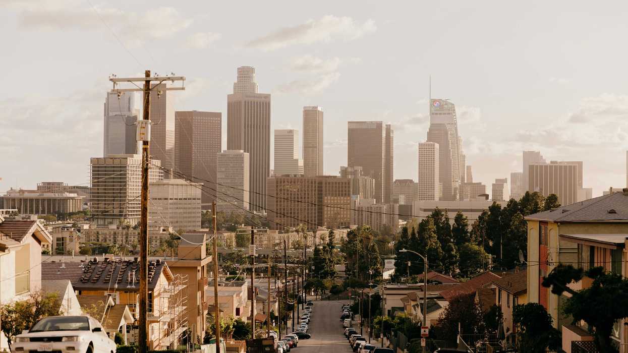 A residential street with Los Angeles skyscrapers in background.