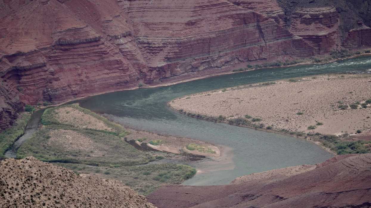 a river running through a canyon surrounded by rocky cliffs.