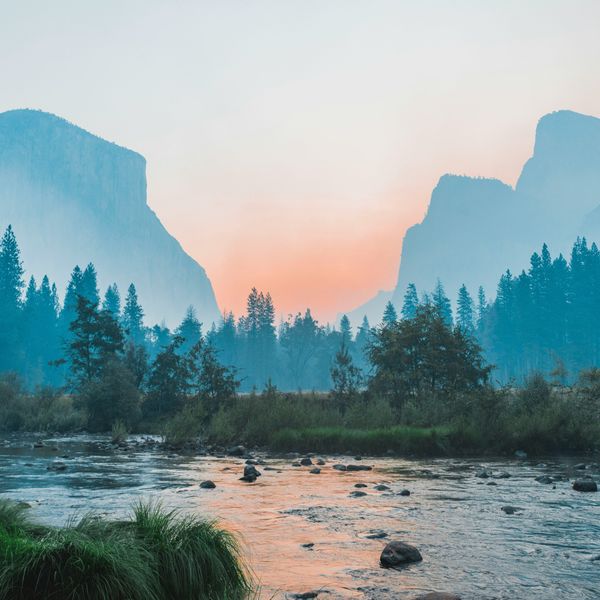 A river running through Yosemite park with half dome in the background.