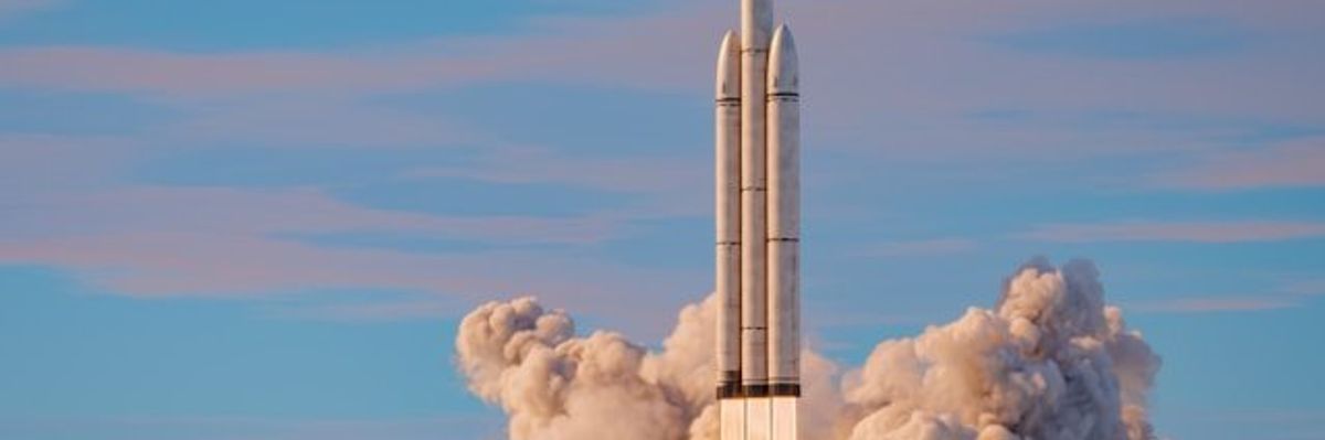 A rocket launch with a blue sky and clouds in the background