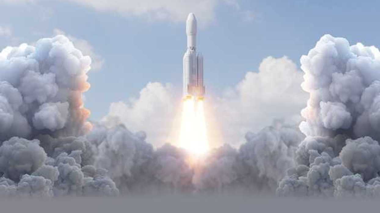 A rocket launching into the sky surrounded by smoke