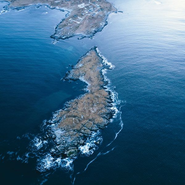 A rocky island in the middle of the ocean viewed from above