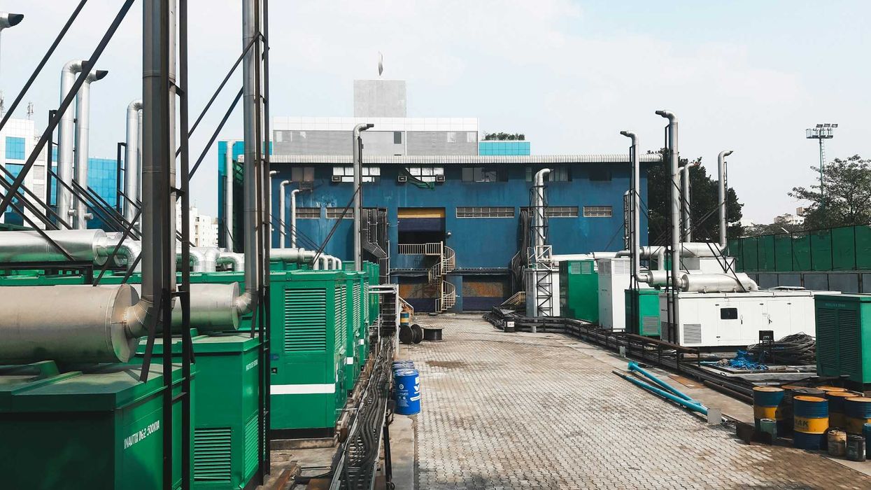 A row of diesel-powered generators outside of an industrial building