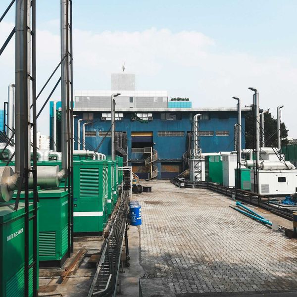 A row of diesel-powered generators outside of an industrial building