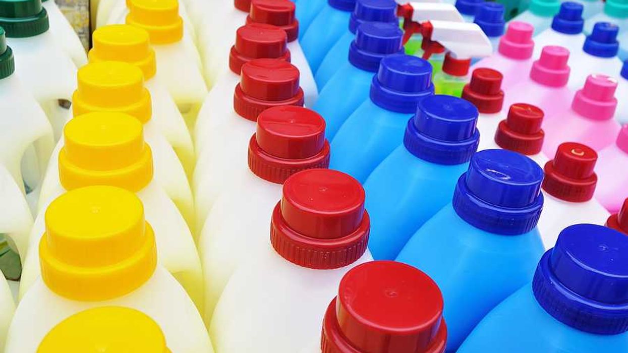 A row of plastic detergent bottles with multicolored lids