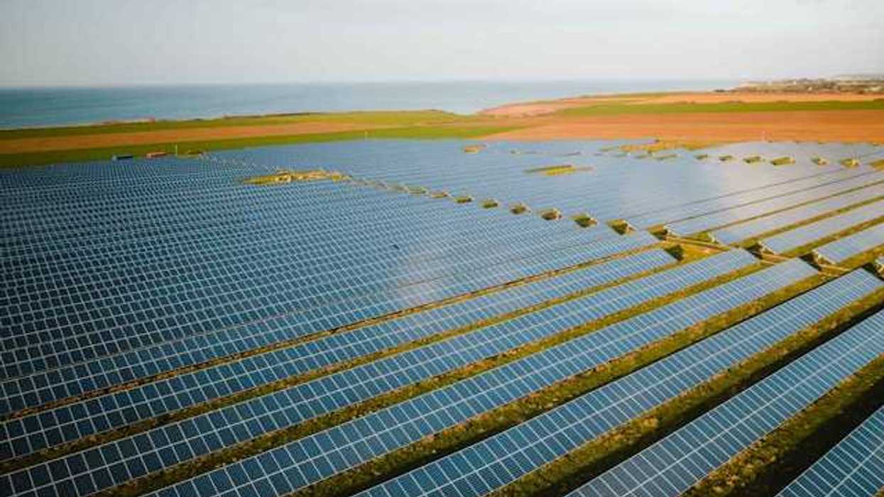 A row of solar panels atop green fields