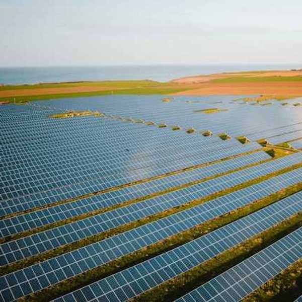 A row of solar panels atop green fields