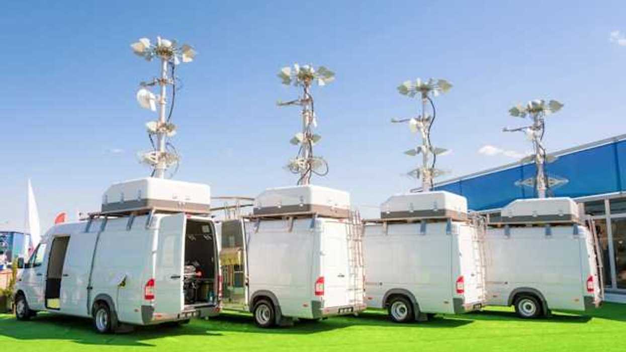 A row of white vans with air and weather monitoring equipment on the roofs