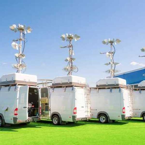A row of white vans with air and weather monitoring equipment on the roofs