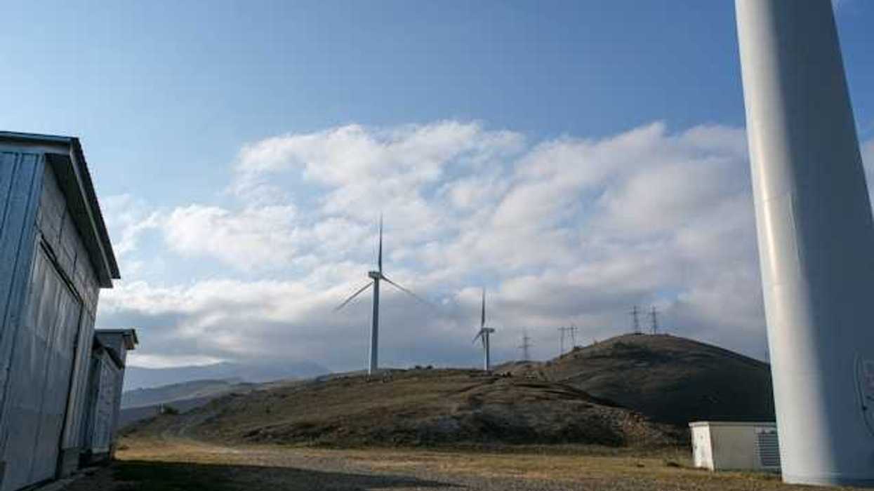 A row of wind turbines on dry hills